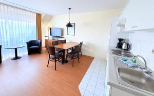 a kitchen and dining room with a table and chairs at Boddenhof Apartment 54 - Balkon, Parkplatz, ruhig in Stedar