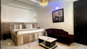 a hotel room with a bed and a chair at Executive Luxury Room - Spa - Gym - Parking in Lekki