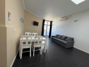 a living room with a table and chairs and a couch at White Pico Lodge in São Roque do Pico