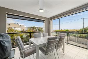 a dining room with a table and chairs and a balcony at Best Location in Woorim - Ocean Front Pool in Woorim