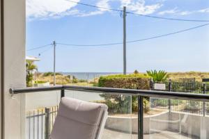 a chair sitting on a balcony with a view of the ocean at Best Location in Woorim - Ocean Front Pool in Woorim +12 photos