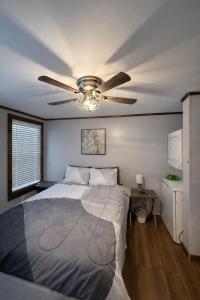a bedroom with a bed and a ceiling fan at The Cozy Cow Cottage in Bluefield