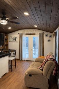 a living room with a couch and a kitchen at The Cozy Cow Cottage in Bluefield