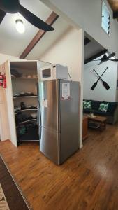a kitchen with a stainless steel refrigerator in a room at Muri Lagoon Cottage in Rarotonga