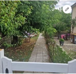 a garden with a sidewalk and trees and chairs at Montignac, t2 proche Lascaux in Montignac