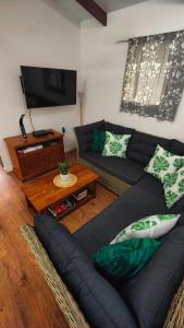 a living room with a couch and a flat screen tv at Muri Lagoon Cottage in Rarotonga