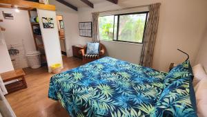 a bedroom with a bed with a blue blanket at Muri Lagoon Cottage in Rarotonga