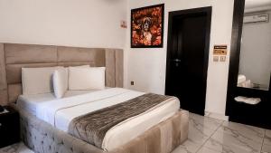 a bedroom with a large bed in a room at Standard Luxury Room - Sleeps2 - Pool - PetAllowed in Lekki +6 photos
