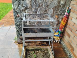 a barbecue grill sitting next to a brick wall at Quarto Grande na Praia do Guaiúba! in Guarujá +4 photos