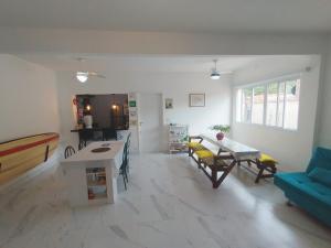 a living room with a blue couch and a table at Quarto Grande na Praia do Guaiúba! in Guarujá