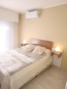 a bedroom with a large bed with two night stands at Céntrico con cochera in Coronel Suárez