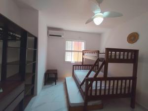 a bedroom with two bunk beds and a ceiling fan at Quarto Grande na Praia do Guaiúba! in Guarujá