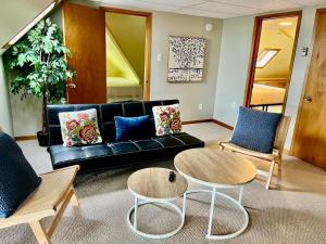 a living room with a black couch and two chairs at Hilltop Landing in Digby +1 photo
