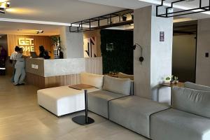 a lobby with a couch and a table and a bar at Flat a 20 metros da praia in João Pessoa