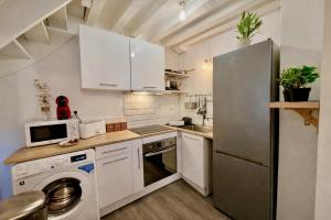 a kitchen with white cabinets and a refrigerator at Le Duplex 4p - 2 chambres, centre Compiègne in Compiègne
