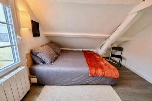 a bed in a small room with a window at Le Duplex 4p - 2 chambres, centre Compiègne in Compiègne