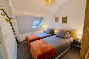 two beds in a small bedroom with a window at Le Duplex 4p - 2 chambres, centre Compiègne in Compiègne +11 photos