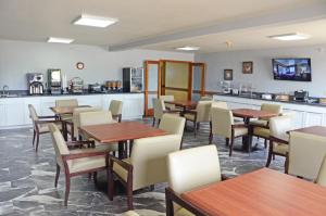 a restaurant with tables and chairs and a kitchen at Heritage Grand Inn in Canton