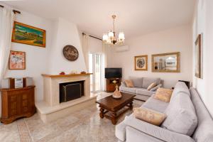 a living room with a couch and a fireplace at Azure Garden Retreat in Aigio
