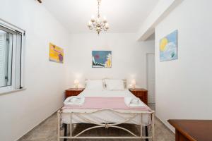a bedroom with a bed and a chandelier at Azure Garden Retreat in Aigio