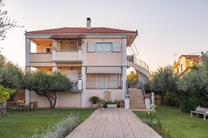 a house with a garden and a patio at Azure Garden Retreat in Aigio