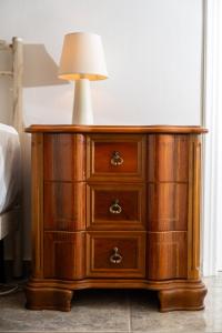a wooden dresser with a lamp on top of it at Azure Garden Retreat in Aigio