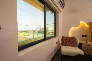a room with a window with a chair and a desk at Ocean View Lekki Ikate in Alaguntan +8 photos