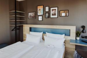 a bedroom with a large bed with white pillows at Schulz Hotel Berlin Wall at the East Side Gallery in Berlin +66 photos
