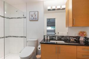 a bathroom with a toilet sink and a shower at Beachbreeze Oceanfront 4BR1Den4BA Romantic Sunrise & Celestial Views in Mill Bay +71 photos