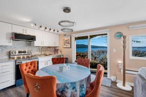 a kitchen and dining room with a table and chairs at Beachbreeze Oceanfront 4BR1Den4BA Romantic Sunrise & Celestial Views in Mill Bay