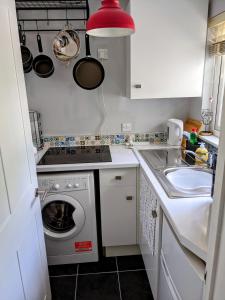 a small kitchen with a washing machine and a sink at Groombridge 1 Bed self catered flat, can sleep 2 in Groombridge +8 photos