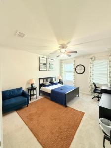 a bedroom with a bed and a blue couch at Abi home in Brandon