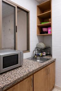 a kitchen with a sink and a microwave on a counter at Diamonds in Rabat