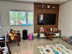 a living room with a flat screen tv on a wall at Casa chácara para alugar no período do festival de Parintins in Parintins