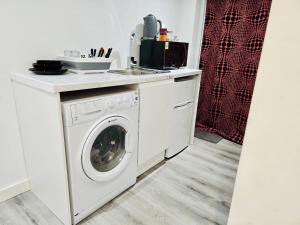 a kitchen with a washing machine and a sink at Enjoy the comfort at private room en-suite with free Parking - near Luton airport in Luton