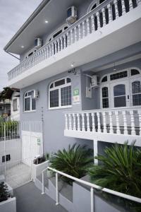 a white house with a white fence in front of it at Mirante Luz Floripa in Florianópolis