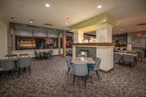 a restaurant with tables and chairs and a fireplace at Coast Bastion Hotel in Nanaimo