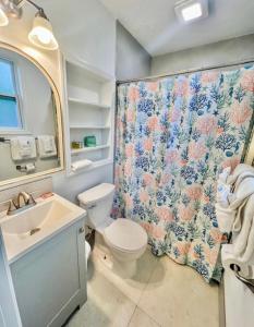 a bathroom with a toilet and a shower curtain at Sunset Cove Beach Resort in Key Largo +92 photos