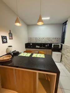 a kitchen with a black counter top in a room at Loft Dominguinhos in Campina Grande