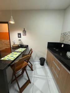 a kitchen with a counter and a wooden chair at Loft Dominguinhos in Campina Grande +12 photos