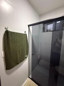 a bathroom with a shower with a green towel at Loft Dominguinhos in Campina Grande