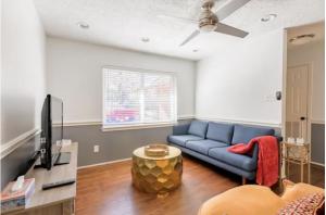 a living room with a blue couch and a tv at Cozy Room with a Pool in Houston