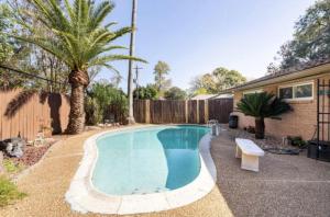 a swimming pool in a yard with a palm tree at Cozy Room with a Pool in Houston +8 photos