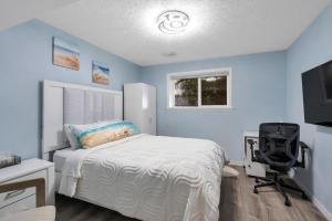 a bedroom with a bed and a desk and a chair at Stunning oceanfront home 4br3b sunrise beachcombing near Bamberton Park in Mill Bay
