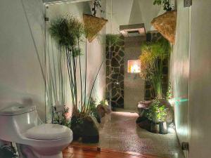 a bathroom with a toilet and plants in it at Sassy Sloth Villa in Fortuna