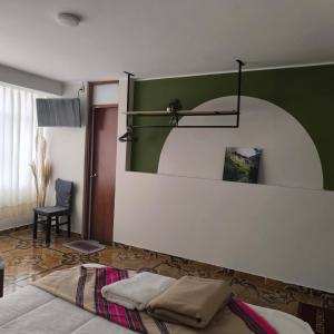 a bedroom with a surfboard on a green wall at Hospedaje Samay Lodge - autogestionado in Chivay