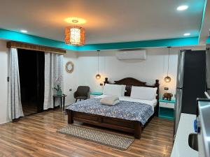 a bedroom with a bed and a chair in it at Sassy Sloth Villa in Fortuna