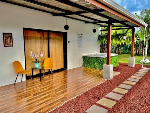 a house with a wooden floor and a table and chairs at Sassy Sloth Villa in Fortuna