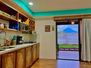 a kitchen with a view of a mountain through a door at Sassy Sloth Villa in Fortuna +22 photos