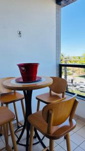 a table with two chairs and a bowl on top of it at Apê com vista para o mar e clima animado in Vitória